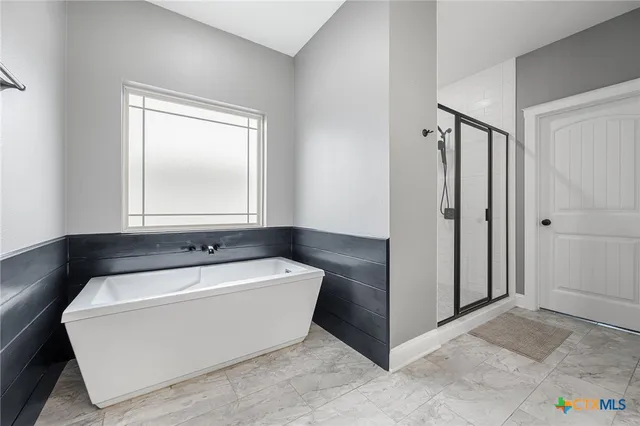 a spacious bathroom with a bathtub sink and mirror