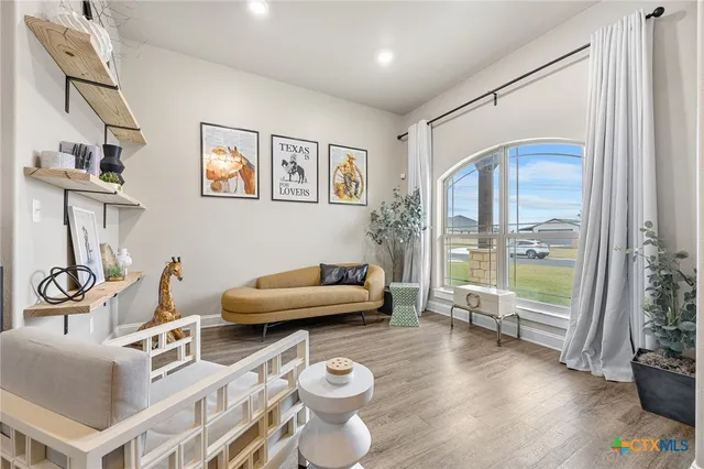 a view of a workspace with furniture and a window