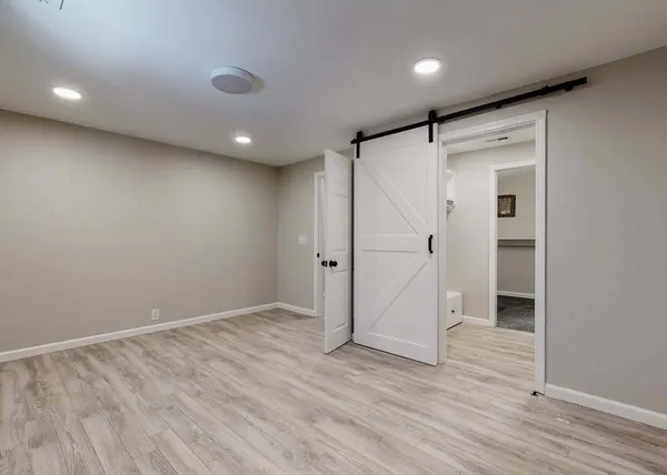 a view of a hallway with wooden floor and cabinet