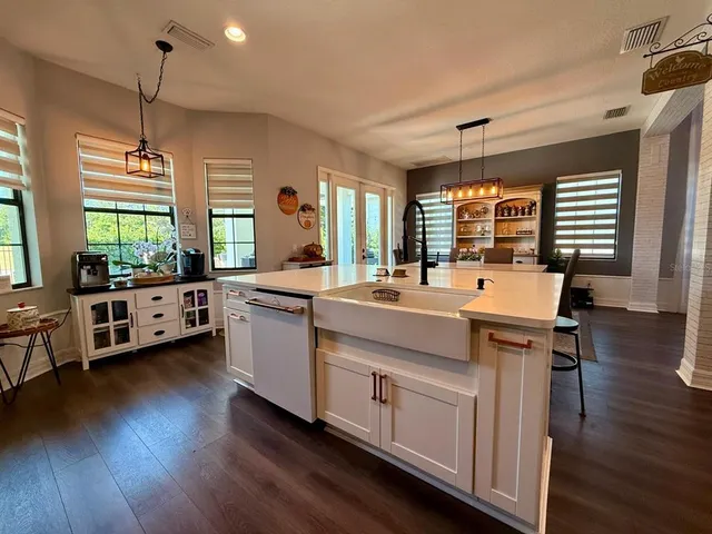 a kitchen with kitchen island a counter top space cabinets and stainless steel appliances