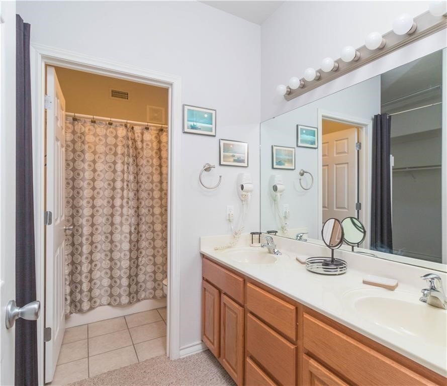 14427 Compass Street, Unit B10 Corpus Christi, TX 78418 - Photo 4 of 16 a bathroom with a double vanity sink mirror and shower