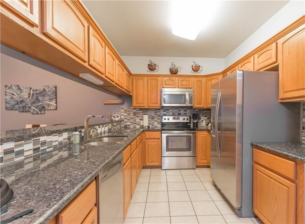 14427 Compass Street, Unit B10 Corpus Christi, TX 78418 - Photo 10 of 16 a kitchen with stainless steel appliances granite countertop a refrigerator a stove and sink