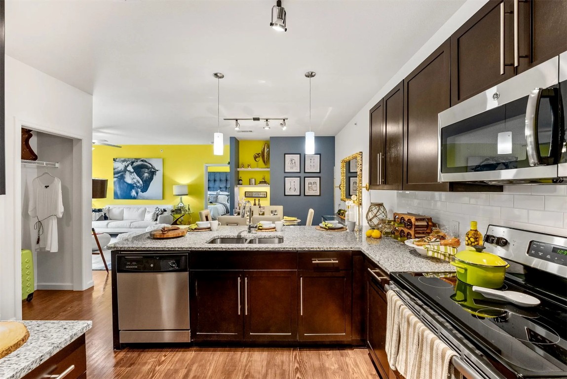 12700 Ridgeline Boulevard, Unit 6308 Cedar Park, TX 78613 - Photo 6 of 16 a kitchen with a sink stove and wooden cabinets