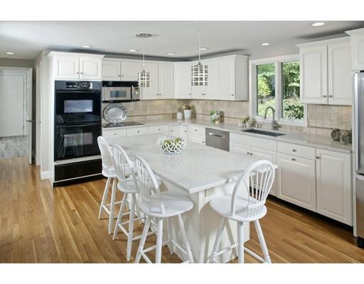 92 Forest Street Duxbury, MA 02332 - Photo 7 of 34 a kitchen with stainless steel appliances a dining table chairs and a refrigerator