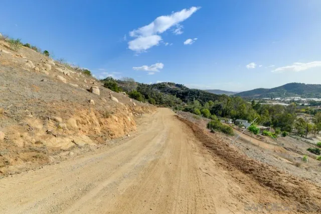 a view of a dry yard with mountains in the background