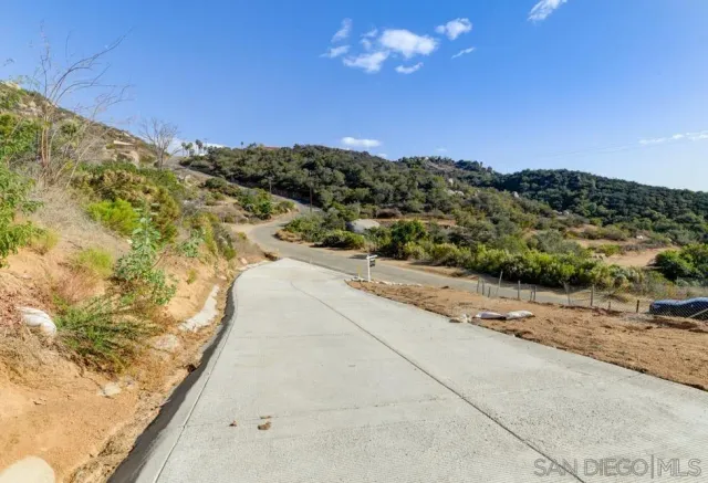 a view of a dry yard with wooden fence