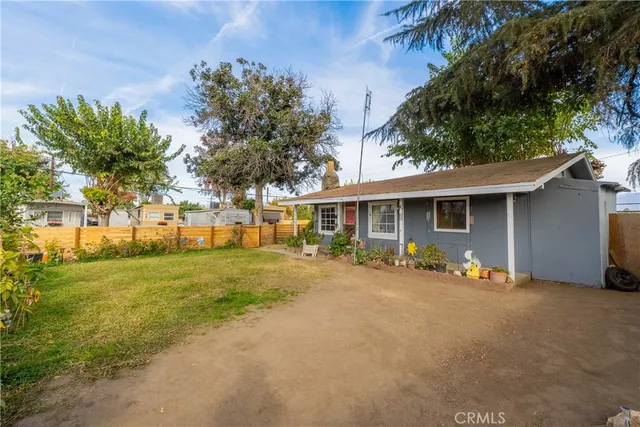 a view of a house with backyard and trees