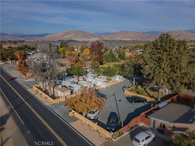 an aerial view of a residential houses with outdoor space and trees