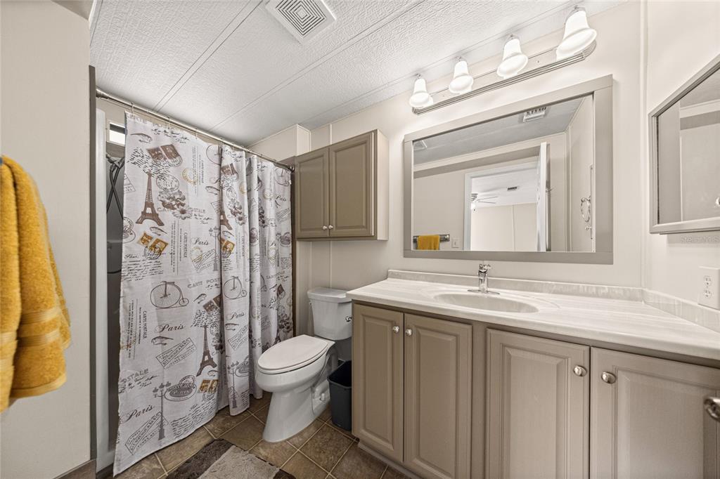 712 Devon Drive Lady Lake, FL 32159 - Photo 16 of 31 a bathroom with a granite countertop sink toilet and shower