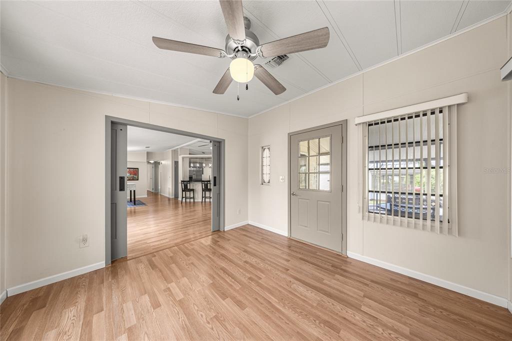 712 Devon Drive Lady Lake, FL 32159 - Photo 5 of 31 wooden floor in an empty room with a window