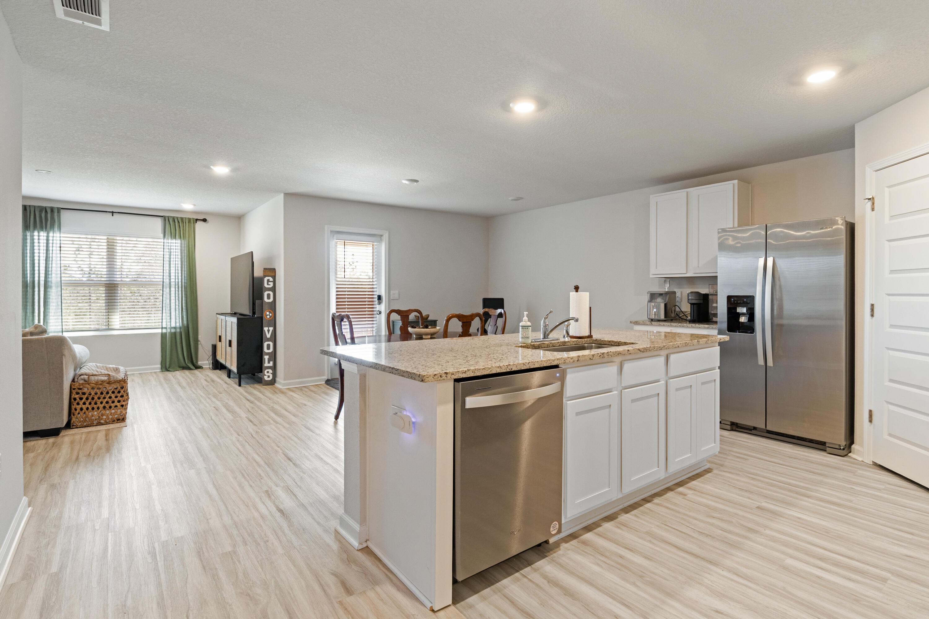 848 Otto Loop Crestview, FL 32539 - Photo 5 of 26 a kitchen with stainless steel appliances granite countertop a refrigerator a sink dishwasher a stove and white countertops with wooden floor