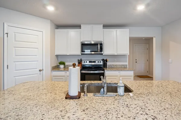 a kitchen with granite countertop a sink and natural light