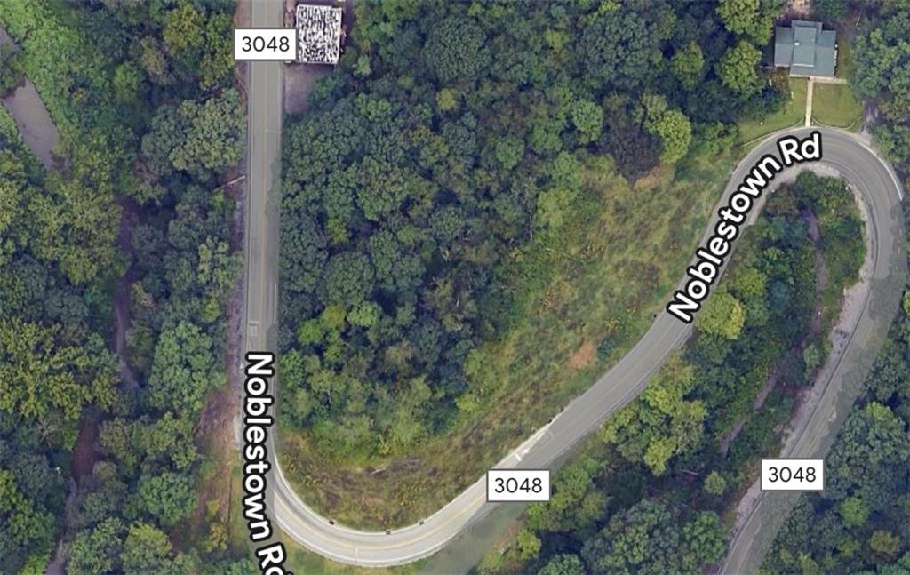 an aerial view of a residential house with an outdoor space and street view