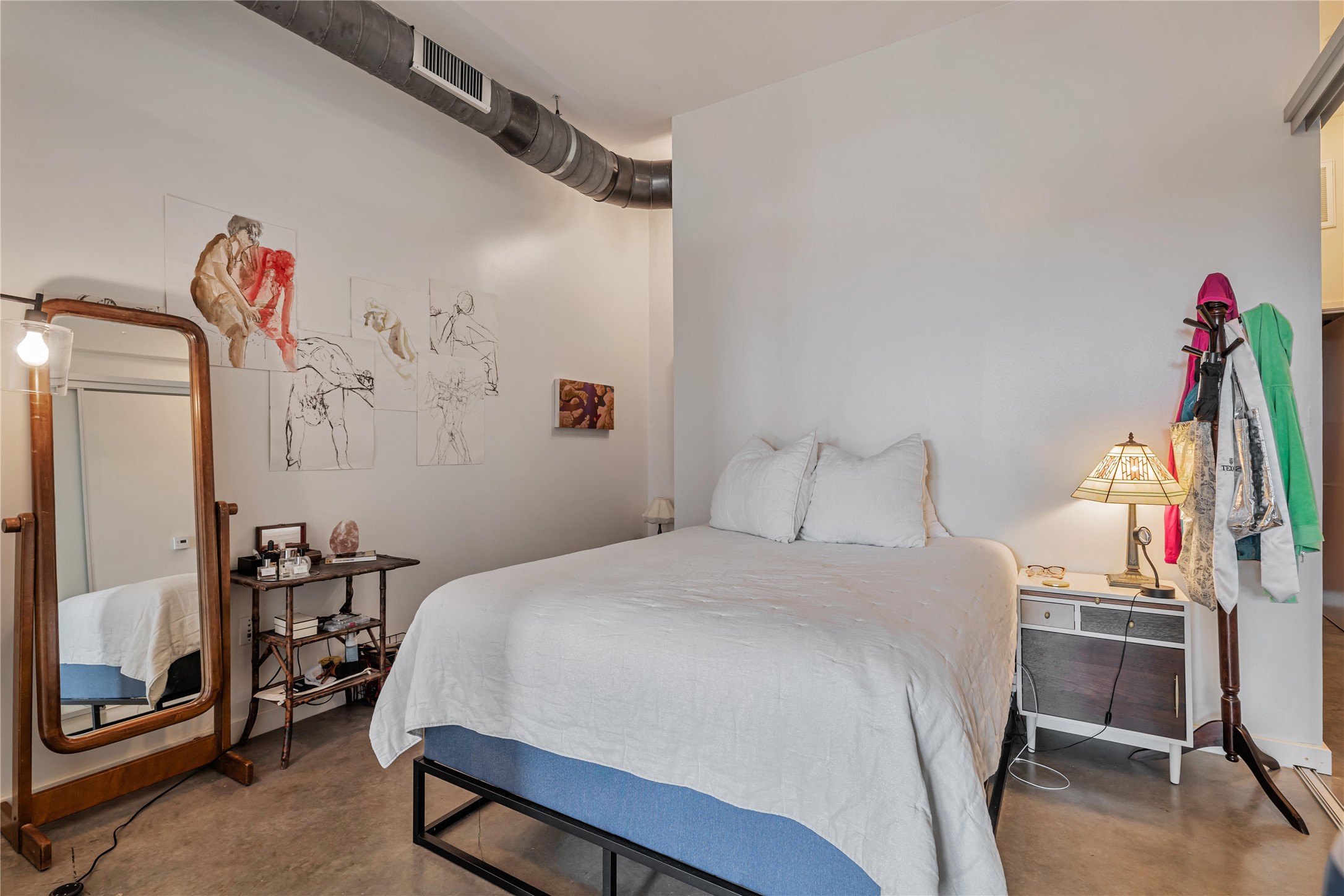 2124 East 6th Street, Unit 305 Austin, TX 78702 - Photo 15 of 35 a bedroom with a bed and a flat tv screen on dresser