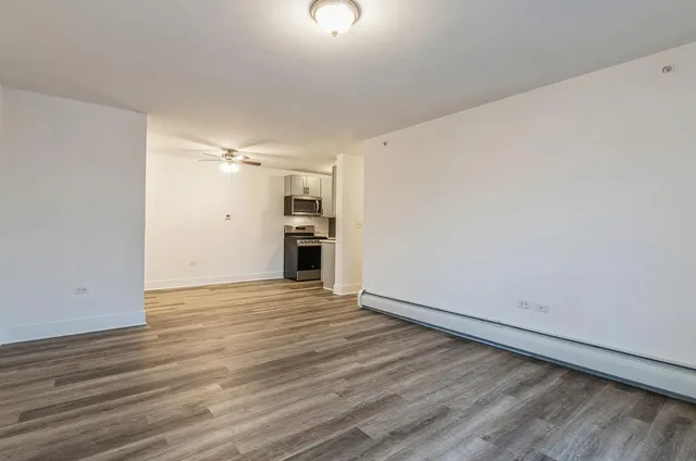 a view of empty room with wooden floor