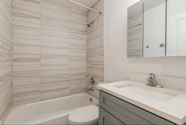 a bathroom with a granite countertop sink toilet and bathtub