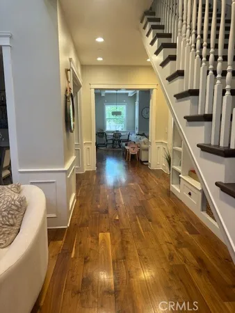 a living room with furniture a large window and wooden floor