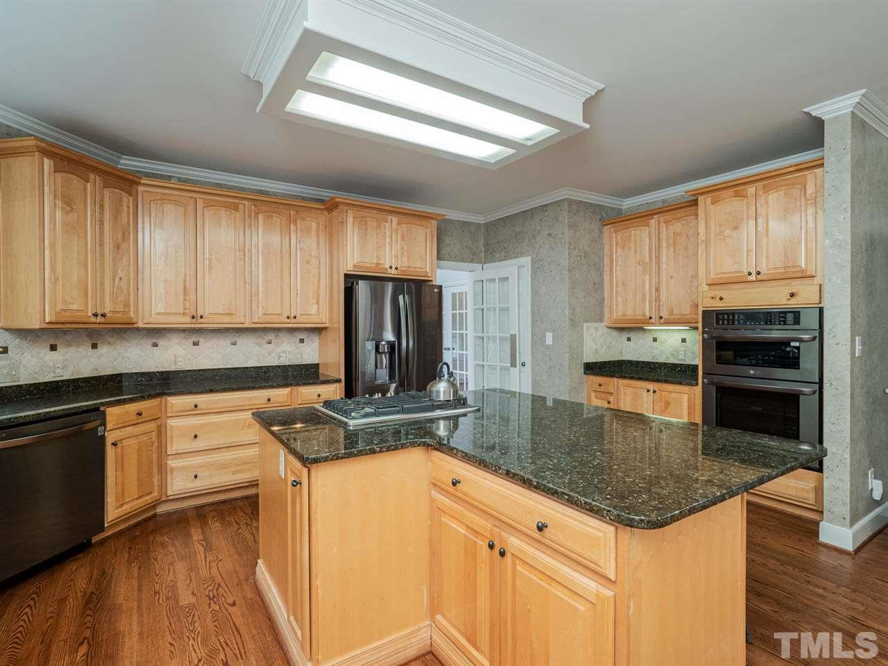 206 Chiselhurst Way Cary, NC 27513 - Photo 12 of 30 a kitchen with stainless steel appliances granite countertop a stove a sink and a microwave