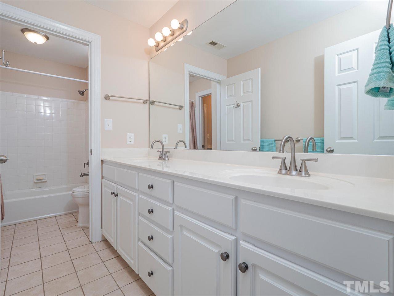 206 Chiselhurst Way Cary, NC 27513 - Photo 25 of 30 a bathroom with a double vanity sink a toilet and a bathtub