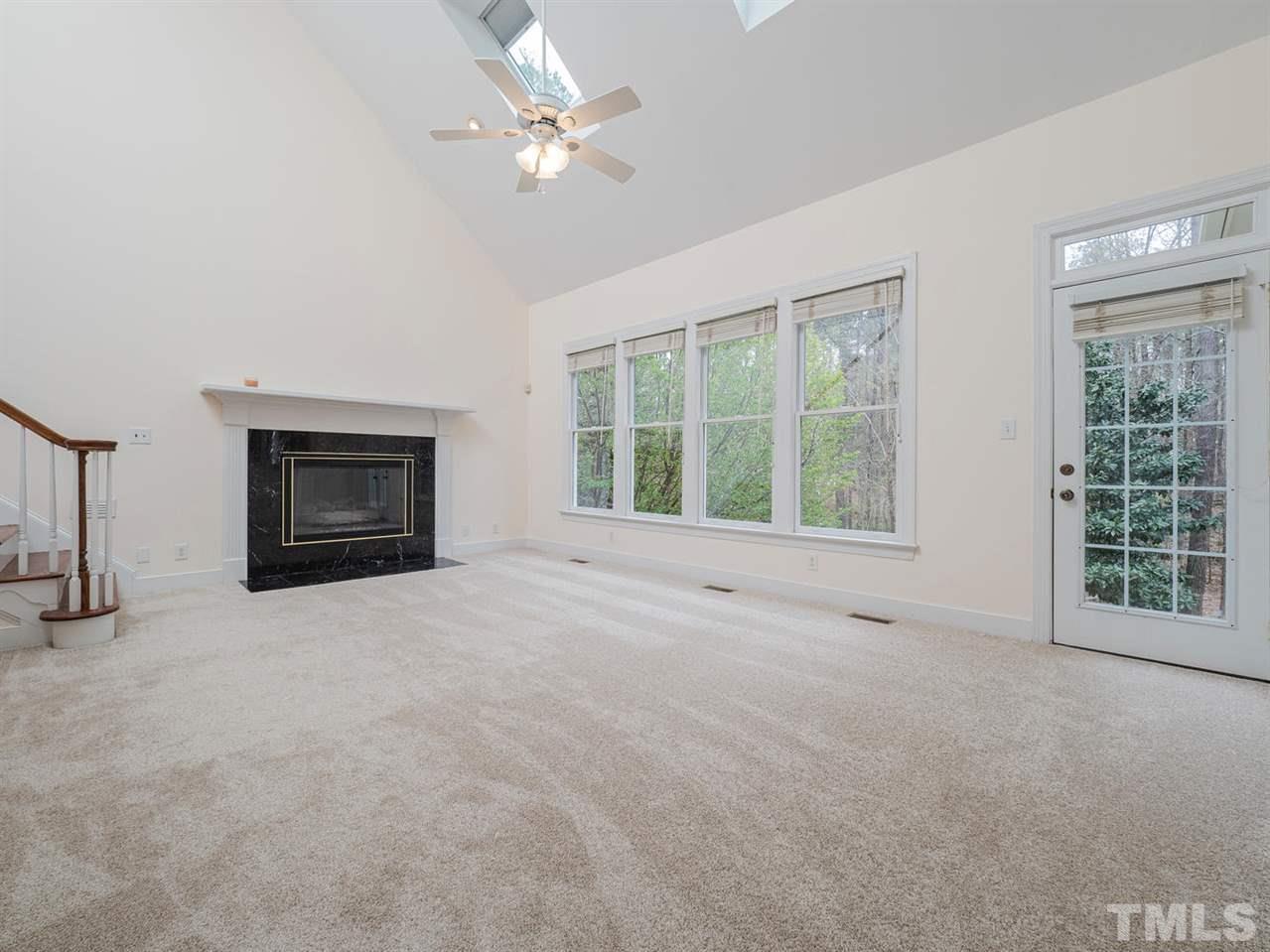 206 Chiselhurst Way Cary, NC 27513 - Photo 8 of 30 a view of an empty room with a fireplace and a window