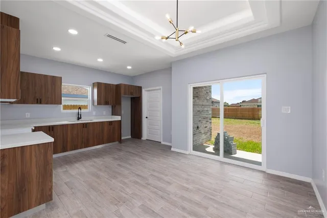 a large kitchen with stainless steel appliances granite countertop a large counter top a sink a refrigerator and a window