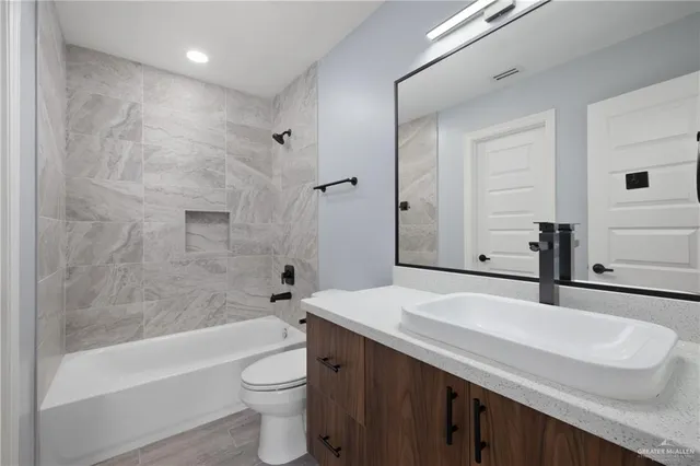 an empty room with wooden floor cabinet and windows