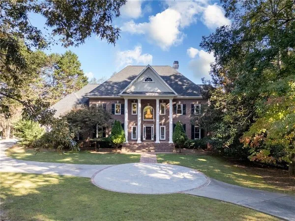a kitchen with stainless steel appliances granite countertop a stove top oven a sink a dining table and chairs with wooden floor