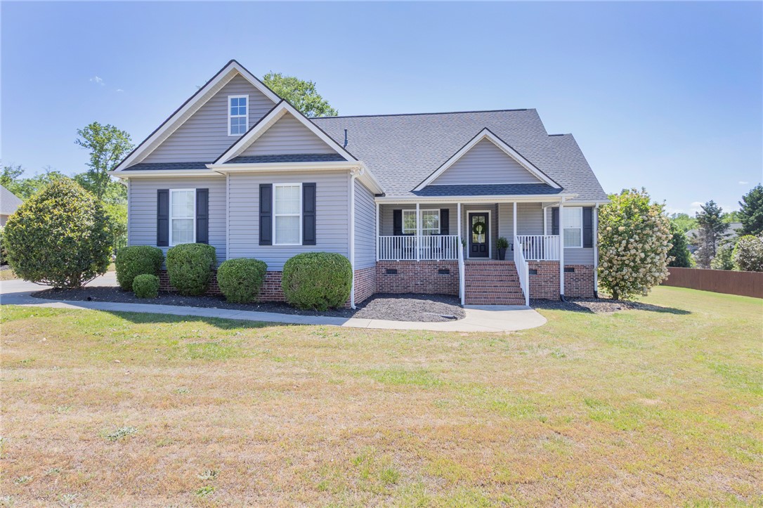 This charming home offers a welcoming facade with a cozy front porch and manicured landscaping.