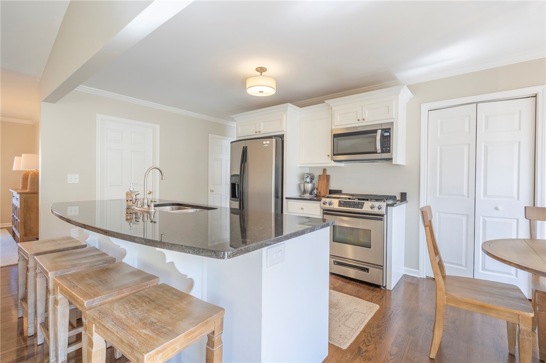 208 Mahaffey Road Williamston, SC 29697 - Photo 15 of 44 This modern kitchen features dark granite counters, stainless steel appliances, and sleek hardwood flooring.