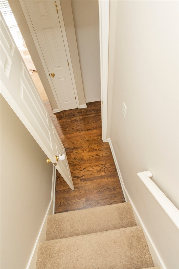 208 Mahaffey Road Williamston, SC 29697 - Photo 36 of 44 This interior hallway features rich hardwood flooring and a carpeted staircase with a clean white railing.