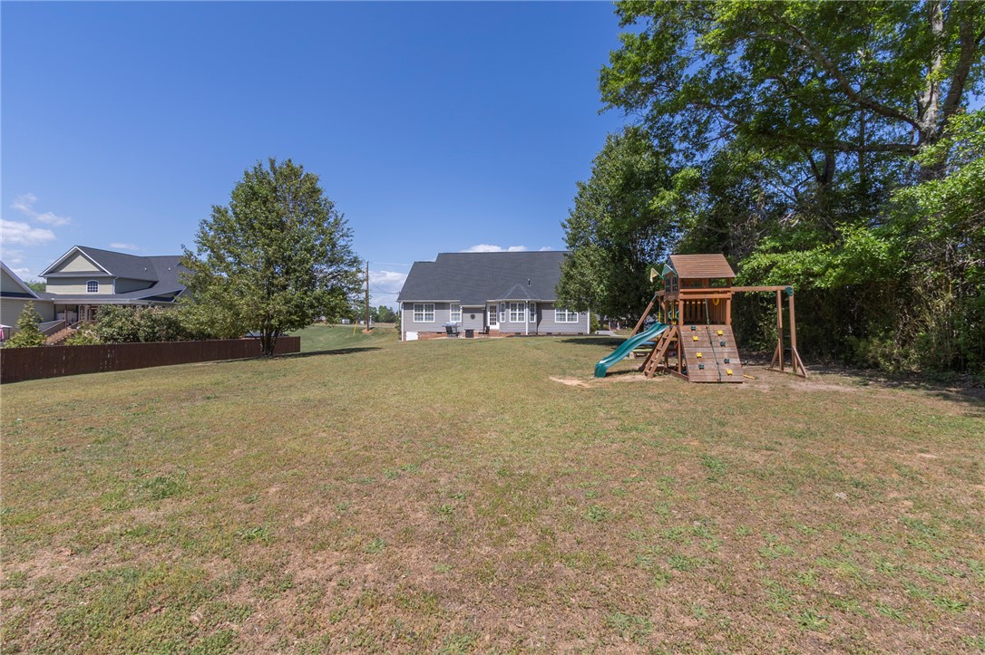 208 Mahaffey Road Williamston, SC 29697 - Photo 42 of 44 This spacious backyard offers ample green space and a dedicated play area for outdoor enjoyment.