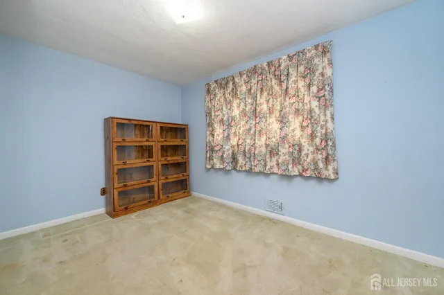 a view of an empty room with a window and closet