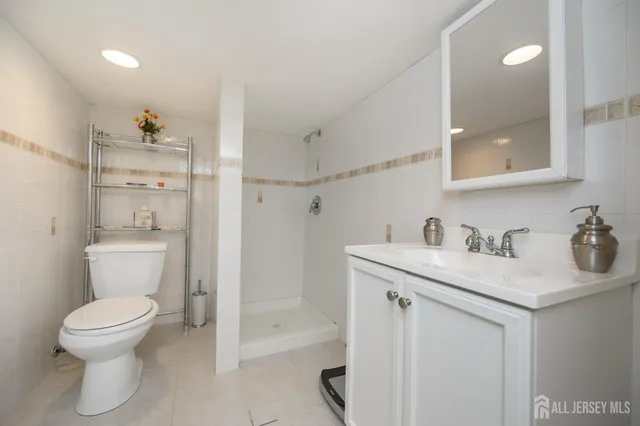 a bathroom with a granite countertop sink a toilet and a mirror