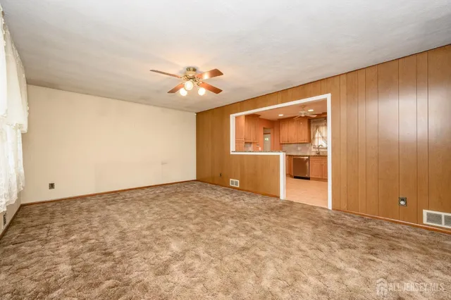 an empty room with closet and windows