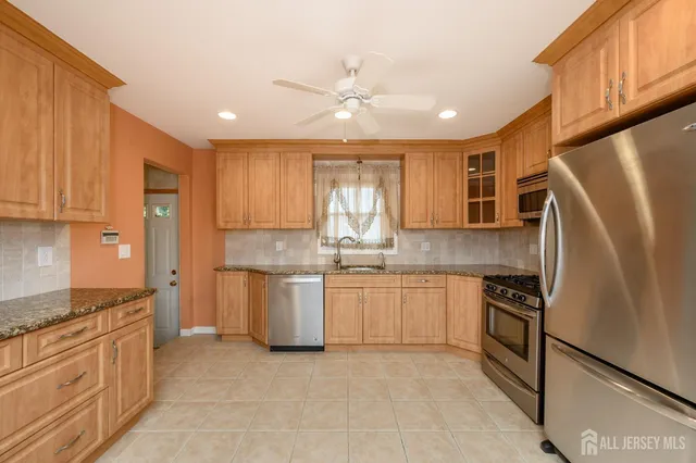 a kitchen with granite countertop cabinets stainless steel appliances and a island