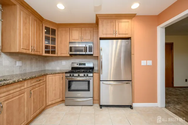 a kitchen with stainless steel appliances granite countertop a refrigerator stove and microwave