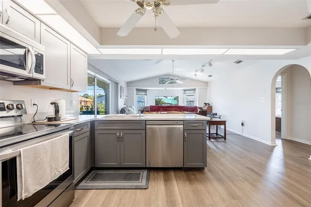 a kitchen with stainless steel appliances granite countertop a white cabinets and wooden floors