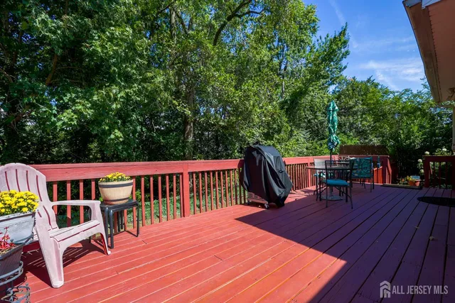 a roof deck view with table and chairs a barbeque with wooden floor and fence