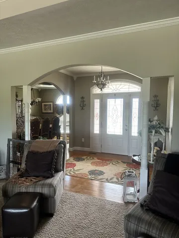 a living room with furniture and a chandelier