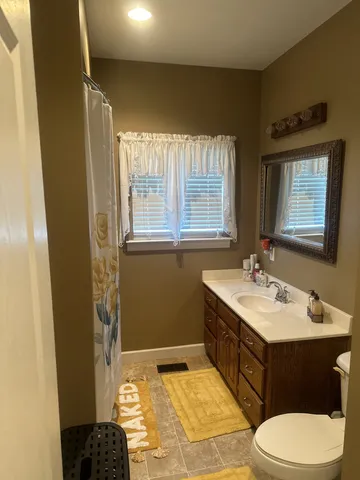 a bathroom with a sink toilet and mirror