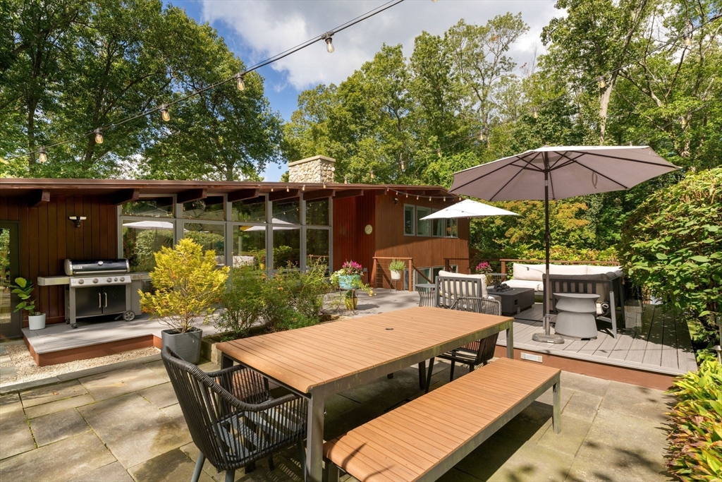 25 Rockwood Road Hingham, MA 02043 - Photo 27 of 32 a patio with a table and chairs under an umbrella