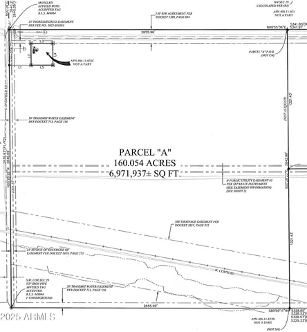 an aerial view of field with trees in background