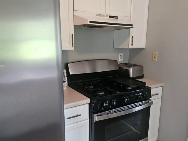 a stove top oven sitting inside of a kitchen