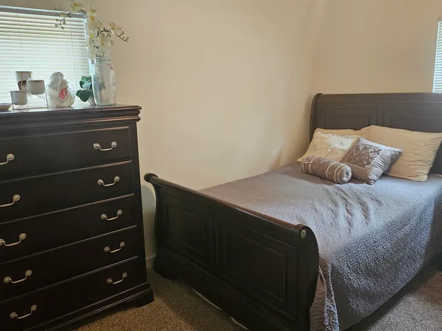 a bedroom with a bed and a potted plant