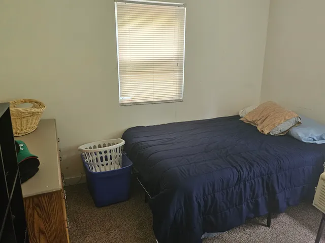 a bed sitting in a bedroom next to a window