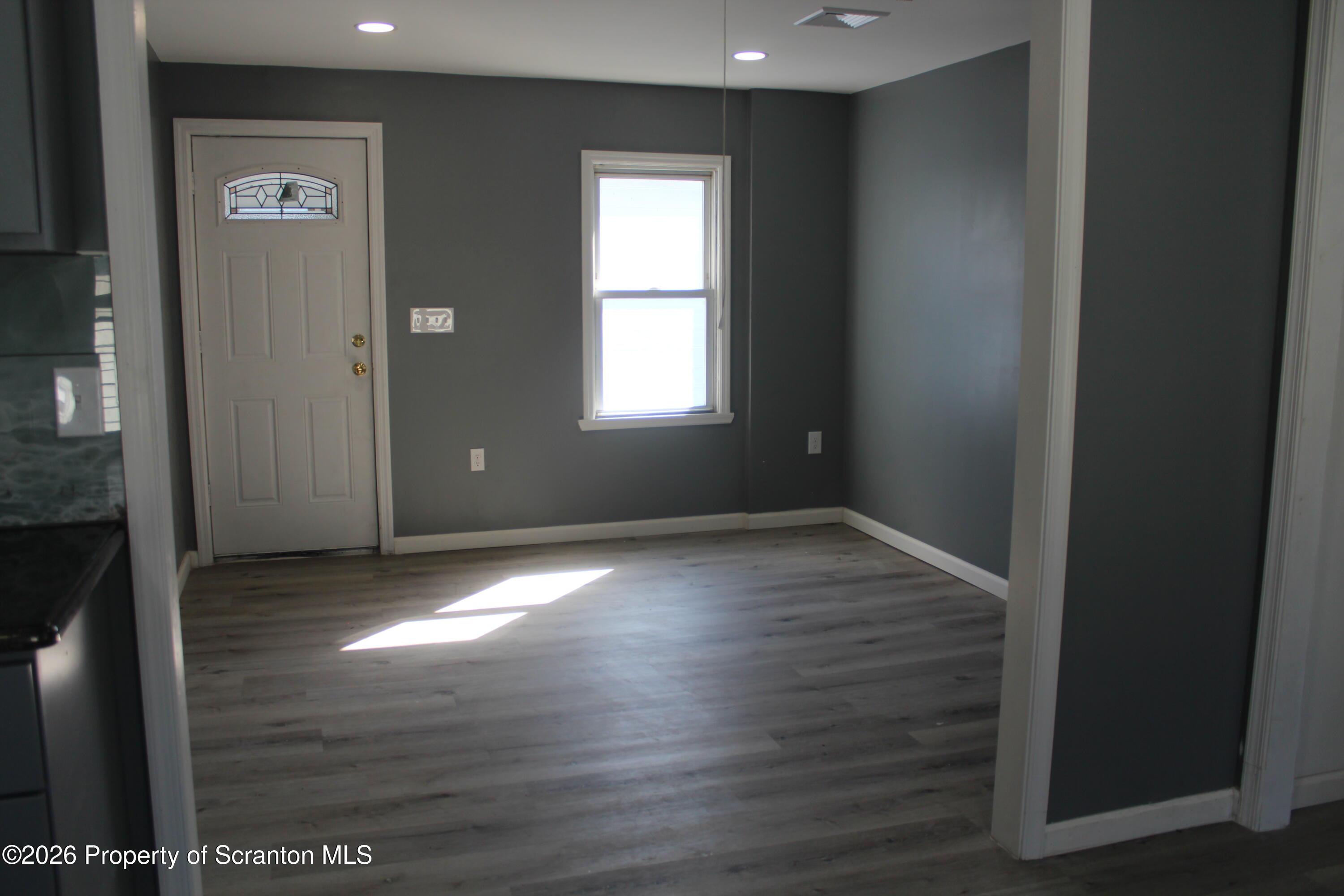 335 Phelps Street, Unit 3 Scranton, PA 18509 - Photo 4 of 15 an empty room with wooden floor and windows