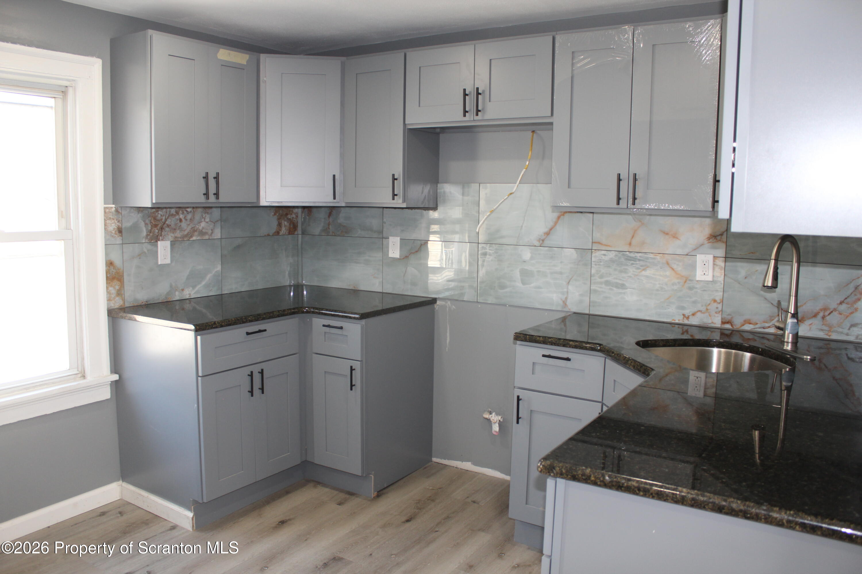 335 Phelps Street, Unit 3 Scranton, PA 18509 - Photo 7 of 15 a kitchen with granite countertop a sink and a stove