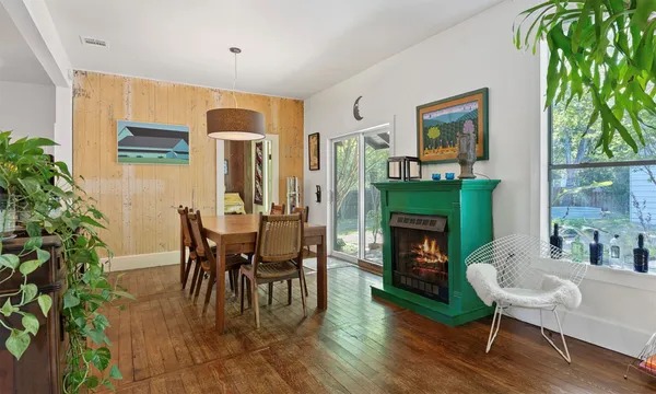 a dining room with furniture a fireplace and a large window