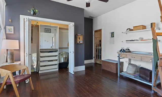 a view of front door with hallway and wooden floor