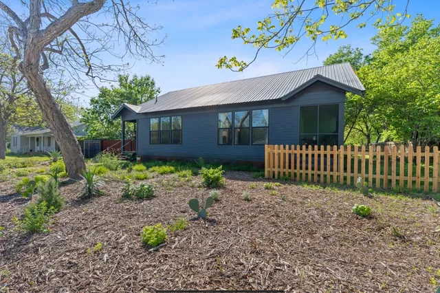 a front view of a house with a garden